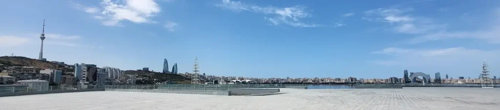 Empty paved seafront in Baku with the Flame Towers and television tower beyond