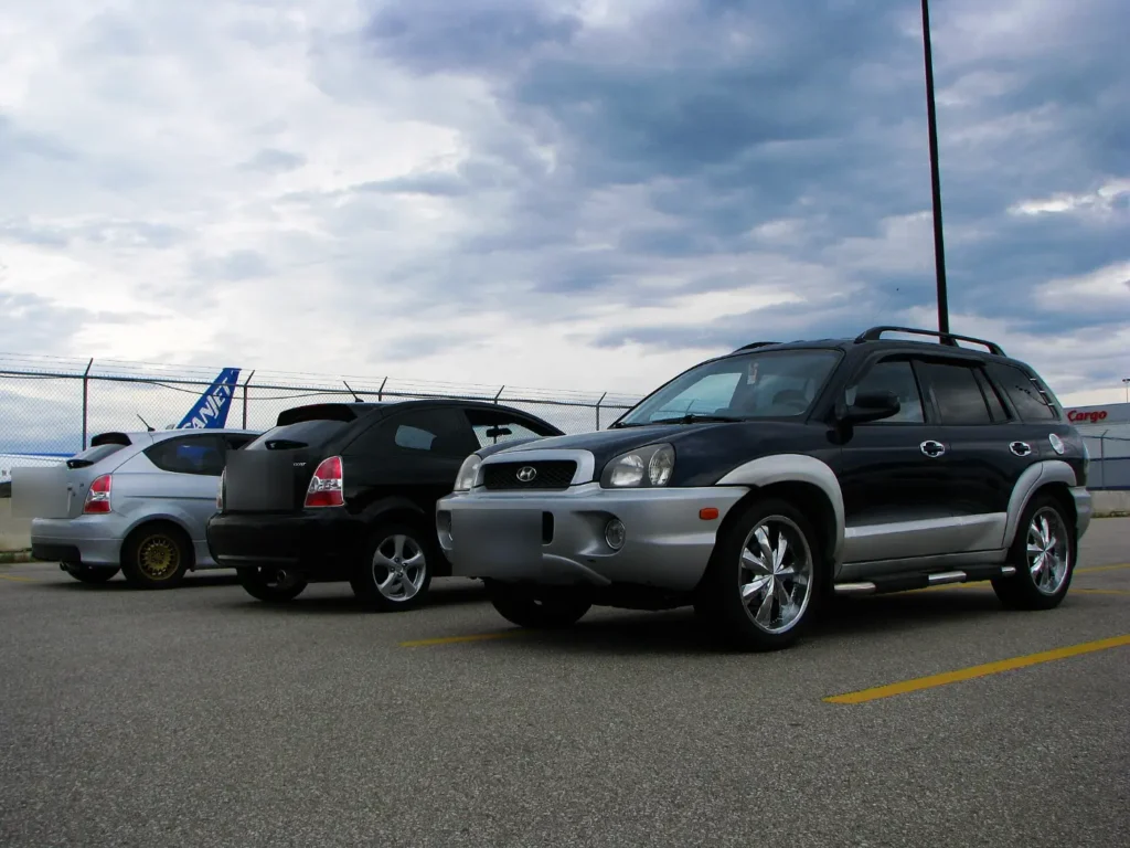 Two small hatchbacks parked next to an SUV